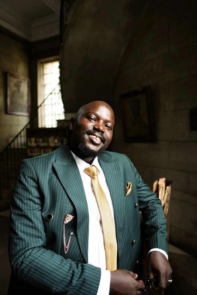 Man in a green pinstripe suit smiling